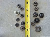 All 15 riveting tool pieces laid out beside tape measure for scale