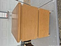 Side view of light wood nightstand showing two drawers