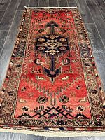 Full view of rug on floor showing design and wear