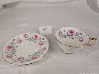 Teacup and saucer front view showing floral design and gold trim
