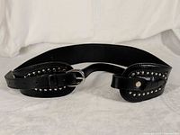 Full view of black studded wide belt laid flat