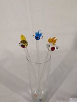 Three handmade glass stir sticks in glass