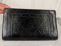 Front view showing tooled floral panel and monogram