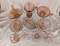 group shot showing all 13 pink glass pieces arranged on cloth