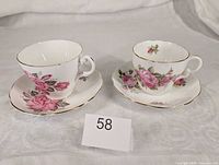 Two teacup and saucer sets with pink rose pattern, lot reference number