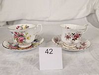 Front view of both teacups on saucers showing patterns and gold trim