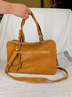 Front view showing leather, color, shoulder handles, detachable strap, exterior zip pocket