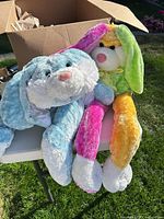 Two large stuffed Easter bunnies in box and on table