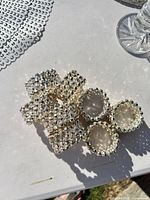 Group of rhinestone napkin rings, partial placemat, crystal candle holder