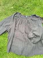 Charcoal crinkle long sleeve blouse laid on grass