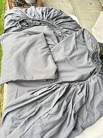 Gray fitted and flat sheets laid out