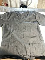 Front view of 4FLEX black scrub top size M showing V-neck, pockets