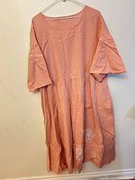 Front view of peach cotton dress on hanger