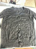 Full flat-lay view showing entire cardigan, buttons, long sleeves, ribbed hem