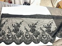 Full view of the lace panel laid flat showing floral design and scalloped edge