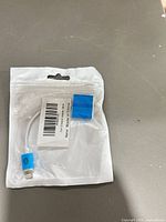 Front of sealed package showing blue Lightning adapter cable and barcode label
