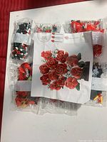 instruction sheet showing finished red rose bouquet alongside sealed bags of bricks