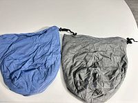 Blue and grey cotton drawstring bags flat exterior view