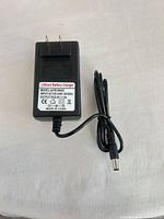 Front view showing label with specifications and attached barrel plug cable