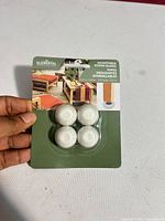 Front of sealed retail card showing four white glide caps