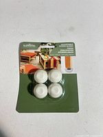 Front of sealed package showing four white screw glides
