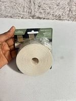Front view of Elemental beige vinyl strap roll in retail package