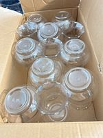 box containing twelve clear glass lamp shades viewed from angle