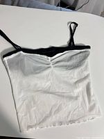 Front view showing white mesh body, black trim and adjustable straps