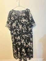 Front view of black floral midi dress on hanger