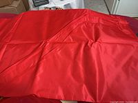 Folded red polyester cover showing overall fabric