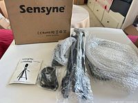 Boxed Sensyne ring light kit contents: ring light, tripod, cable, manual