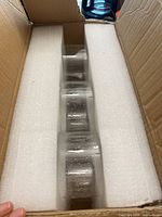 Open box showing three of the glass shades seated in foam