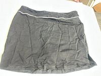 Front view of black skort, showing white piping and overall condition