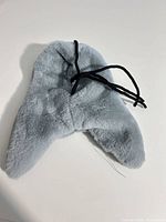Front view of grey faux fur trapper hat showing ear flaps and ties