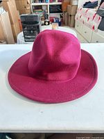 Top and front view of burgundy fedora on table
