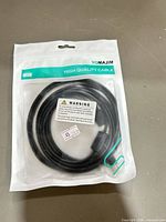 Front of sealed package showing coiled black HDMI cable and branding