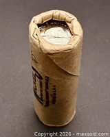 Unopened paper roll showing one end coin obverse