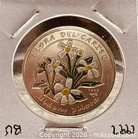 Obverse view showing colourized Romerillo flowers, legend, date