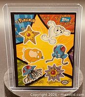 Front of puzzle sticker card in sleeve showing star design and six Pokémon