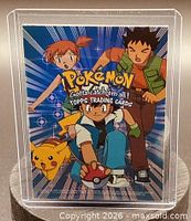 Front of the checklist trading card showing Ash, Pikachu, Misty, Brock