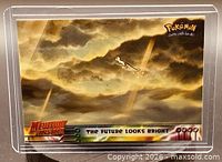 Front of card in holder showing cloud artwork with Mew