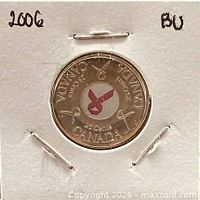 Front of 25-cent coin in holder showing colourized pink ribbon reverse