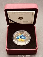 Coin in open burgundy RCM clamshell case with info card