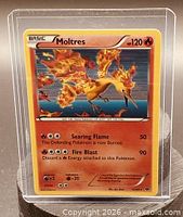 Front view showing Moltres card details and protective sleeve