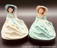 Front view of both ceramic lady figurines on black bases