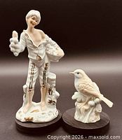 Front view of both porcelain figurines on wood bases