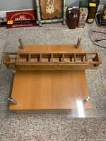 Front view of wooden Alexander Keith's 8-can rack on glass table