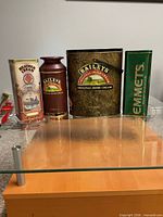 Front view of four branded liquor tins on surface