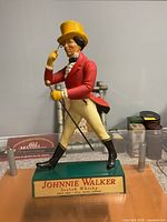 Front view of Johnnie Walker Striding Man figurine on base