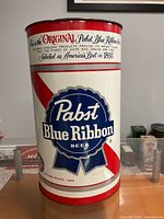 Full view of cylindrical garbage can with Pabst Blue Ribbon graphics